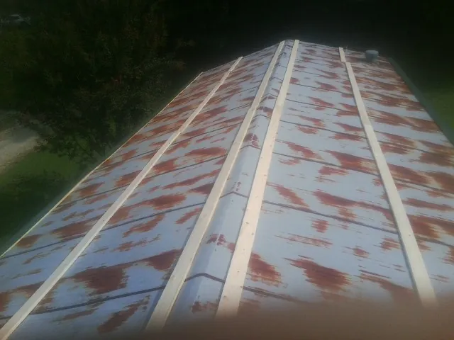Rusted metal roof panels with new wood purlins before replacement — Storm Damage Roof Repair in Idleyld Park by Roofing Brothers