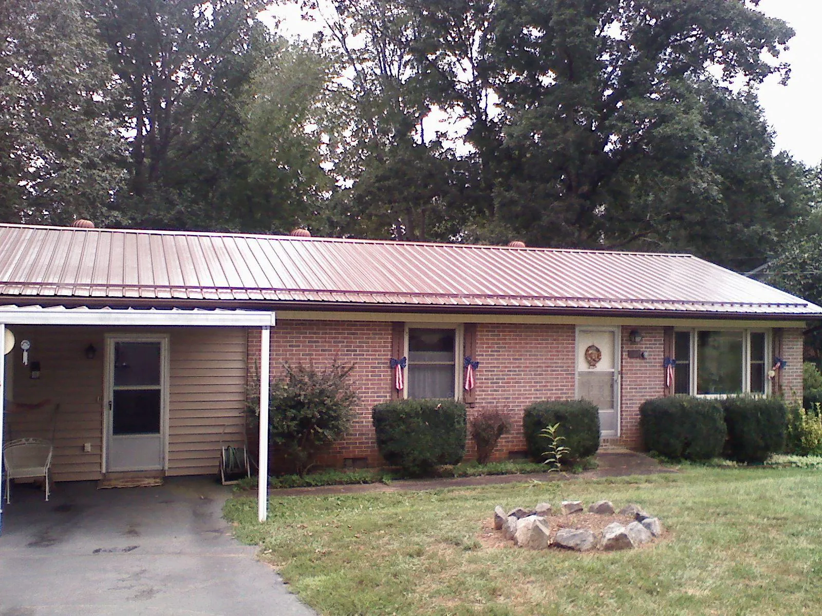 Bronze metal roof and carport on a brick ranch home — Roof Repair work by our crew in Idleyld Park